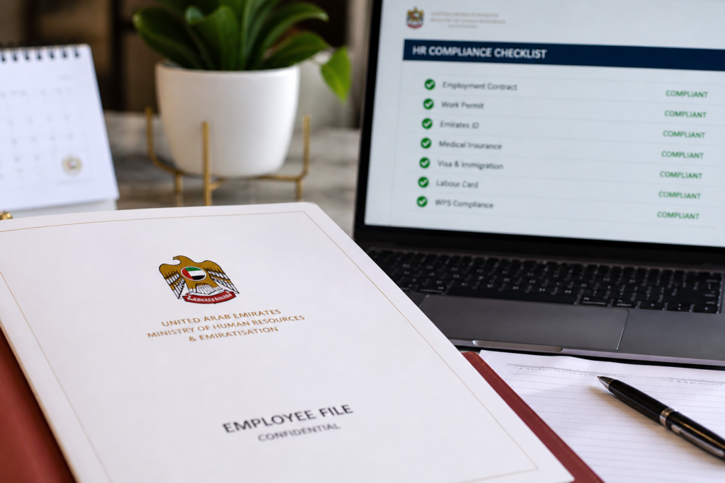 UAE document folder with flag emblem beside laptop showing HR compliance checklist on desk