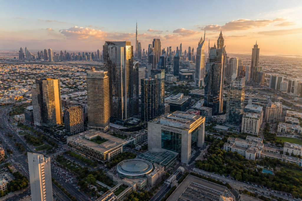 Aerial view of Dubai's DIFC business district with modern skyscrapers at golden hour.